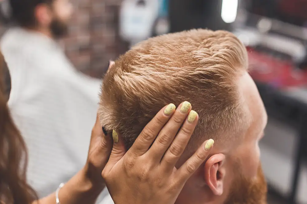 Stylist checking a man's freshly cut short hair